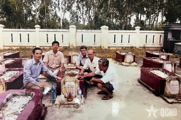Đoàn tìm kiếm bên bia mộ liệt sĩ Lê Văn Bồ. Ảnh do gia đình cung cấp