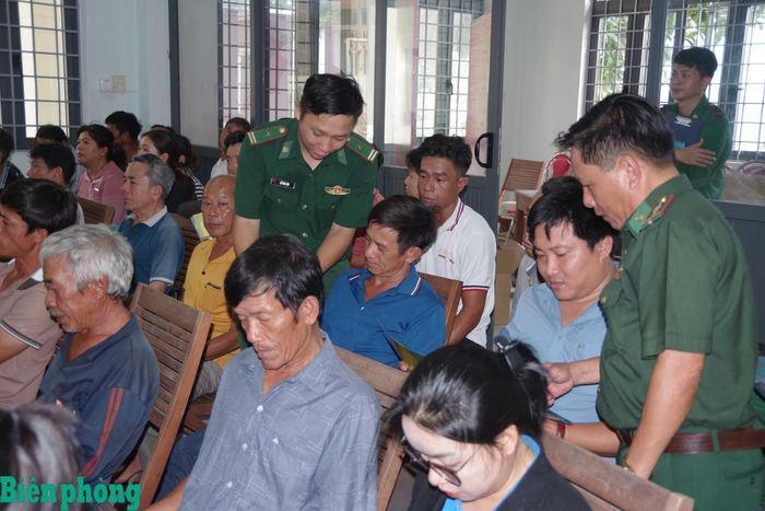 Cán bộ Đồn Biên phòng cửa khẩu cảng Quy Nhơn phát tờ rơi tuyên truyền pháp luật cho ngư dân phường Quy Nhơn Nam. Ảnh: Công Cường