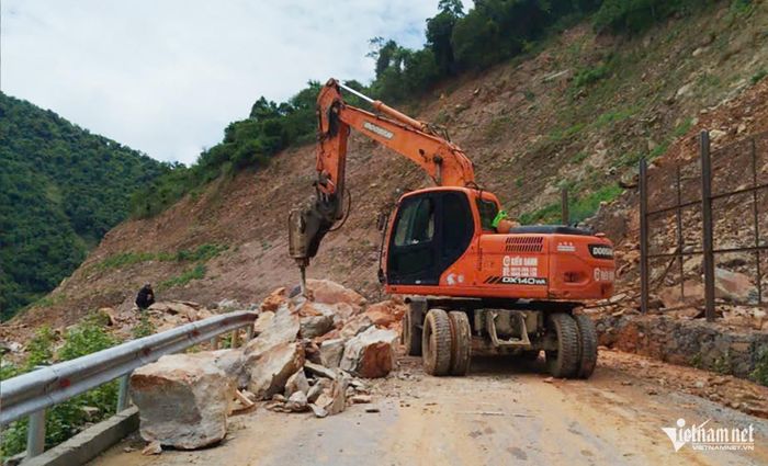 Lực lượng chức năng điều động máy móc phá đá, giải phóng điểm sạt lở. Ảnh: X.H