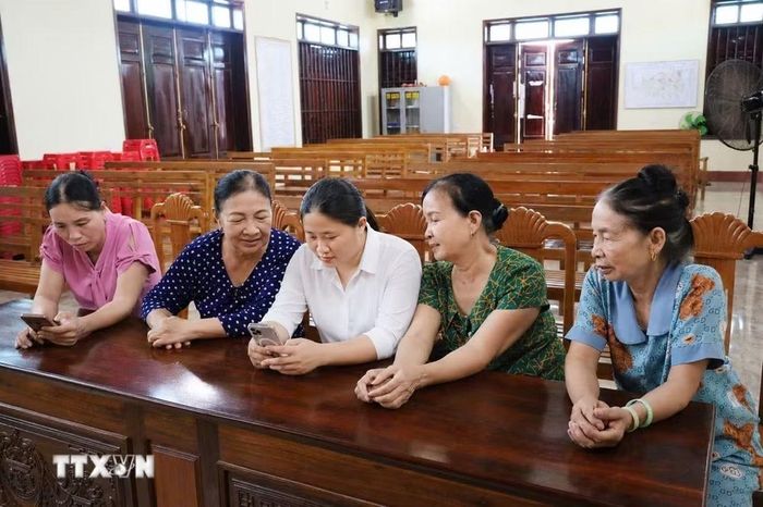 Trưởng thôn Phú Lộc, xã Hoa Lộc hỗ trợ người dân ứng dụng công nghệ thông tin khi thực hiện thủ tục hành chính. (Ảnh: Khiếu Tư/TTXVN)
