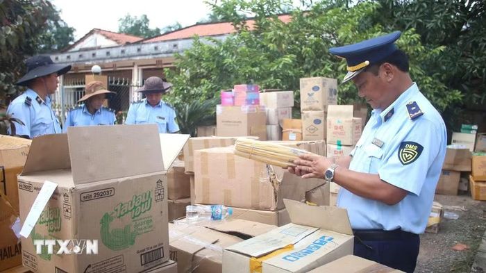 Cán bộ quản lý thị trường tỉnh Tây Ninh kiểm tra sản phẩm nghi không rõ nguồn gốc, xuất xứ. (Ảnh: Minh Phú/TTXVN)