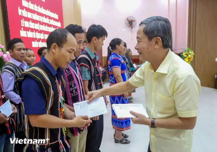 Ông Vũ Quang Hùng (hình trái), Giám đốc Ban Quản lý Khu Công nghệ cao và các khu công nghiệp Đà Nẵng và ông Phạm Tấn Tư, Giám đốc Đài Tiếng nói Việt Nam khu vực miền Trung tặng quà cho các hộ dân khó khăn. (Ảnh: PV/Vietnam+)