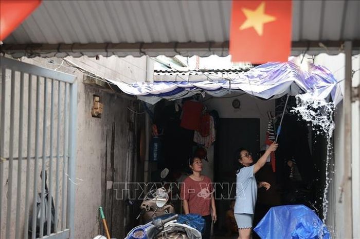 Tổ công tác Trạm y tế phường Ba Đình kiểm tra, hướng dẫn người dân thực hiện đậy kín các dụng cụ chứa nước, thay nước bình hoa, chậu thủy sinh thường xuyên; lật úp các vật dụng không sử dụng, không để nước đọng. Ảnh: Minh Quyết/TTXVN