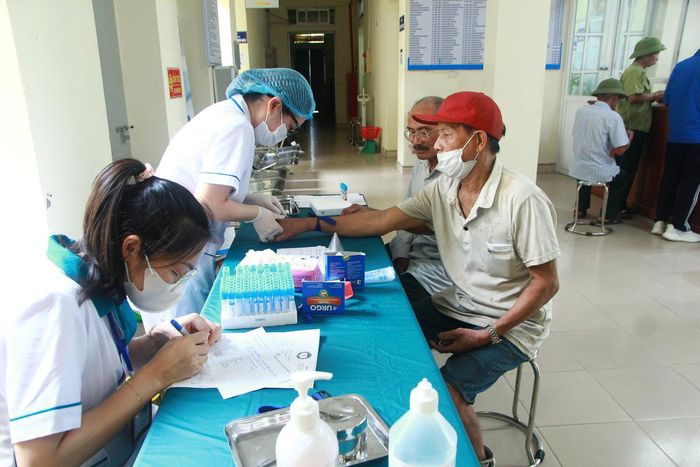 Nhân viên tại trạm y tế lấy máu cho người dân.