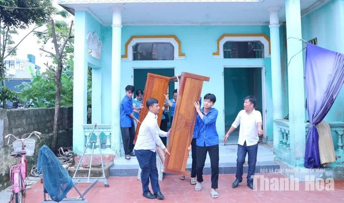 Cấn bộ Ủy ban MTTQ phường và đoàn viên thanh niên hỗ trợ hộ dân di dời đồ đạc.