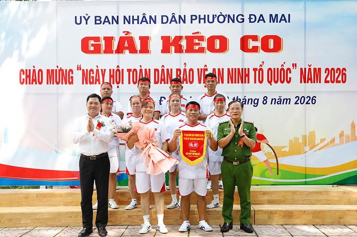  Thượng tướng Nguyễn Văn Long và Bí thư Tỉnh ủy Nguyễn Hồng Thái trao cờ lưu niệm cho tổ dân phố Lò - đội thi giành giải Nhất hội thi kéo co. 