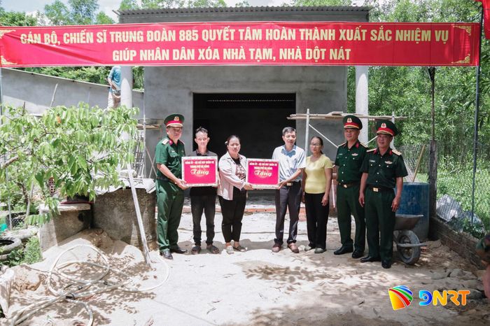 Lãnh đạo Bộ Chỉ huy Quân sự thành phố tặng quà cho gia đình được hỗ trợ xóa nhà tạm, nhà dột nát trong chương trình tại xã Quế Sơn. Ảnh: Q.CƯỜNG