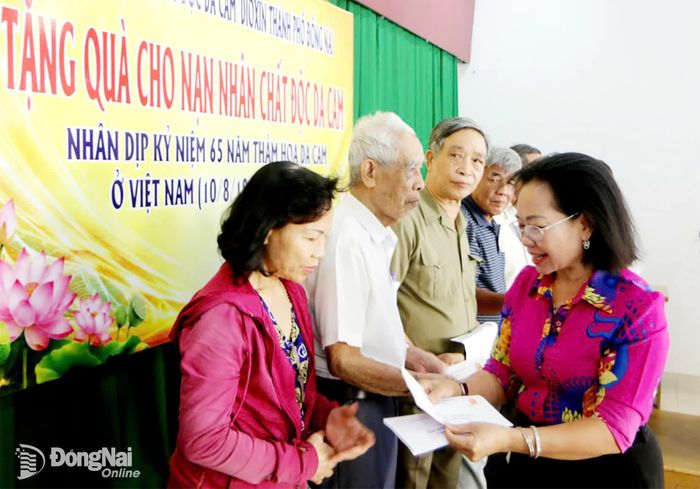 Lãnh đạo Hội Nạn nhân chất độc da cam/dioxin thành phố Đồng Nai tặng quà cho nạn nhân ở phường Tân Triều và Trấn Biên ngày 5-8. Ảnh: Văn Truyên