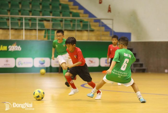 Cầu thủ U.11 Đồng Nai thực hiện pha đi bóng kỹ thuật, vượt qua sự truy cản của cầu thủ U.11 C.P. Việt Nam. Ảnh: Thủy Tiên