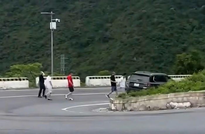 Ô tô 7 chỗ dừng ngay giữa khúc cua trên đèo Hải Vân để nhóm người xuống ngắm cảnh nguy cơ cản trở tầm nhìn, gây TNGT cho các phương tiện lưu thông.