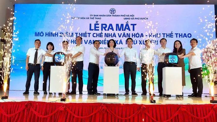 Các đại biểu thực hiện nghi thức bấm nút công bố vận hành thí điểm mô hình tổ chức hoạt động tại Nhà văn hóa - Khu thể thao thôn Vạn Điểm.