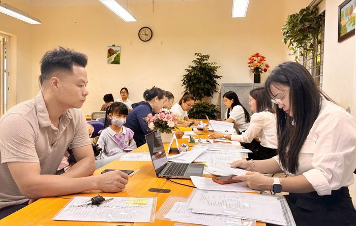 Hướng dẫn phụ huynh làm thủ tục tuyển sinh lớp 1 tại Trường Tiểu học Trần Phú (phường Hà Đông). Ảnh: Minh Ngọc