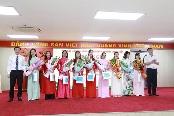 Lãnh đạo phường Dương Nội trao quà lưu niệm cho cán bộ thôi giữ chức vụ quản lý sau sắp xếp. Ảnh Thu Oanh