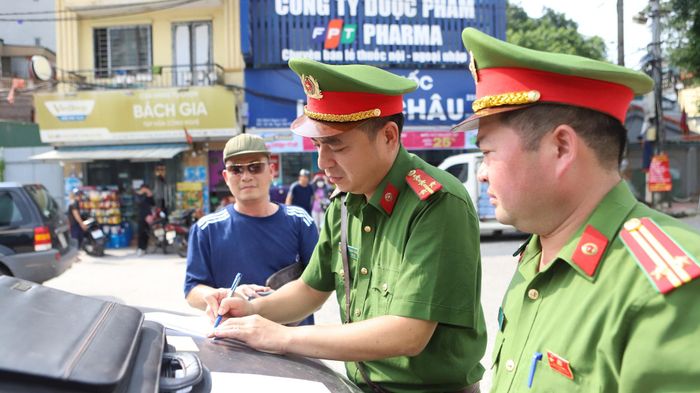CAP Định Công xử phạt các trường hợp ô tô dừng đỗ sai quy định trước khuôn viên KĐT Kim Văn - Kim Lũ. Ảnh: Huy Hoàng