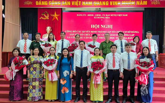 Lãnh đạo xã Dương Hòa tặng hoa chúc mừng các trường sau sắp xếp. Ảnh: Hậu Lộc