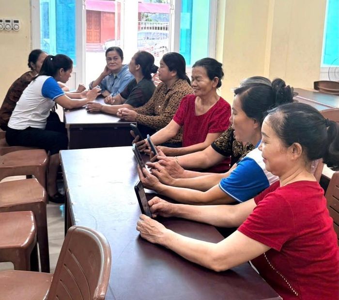 Thành viên Tổ chuyển đổi số hướng dẫn người dân sử dụng các chức năng trên điện thoại thông minh. Ảnh: Biên Phạm