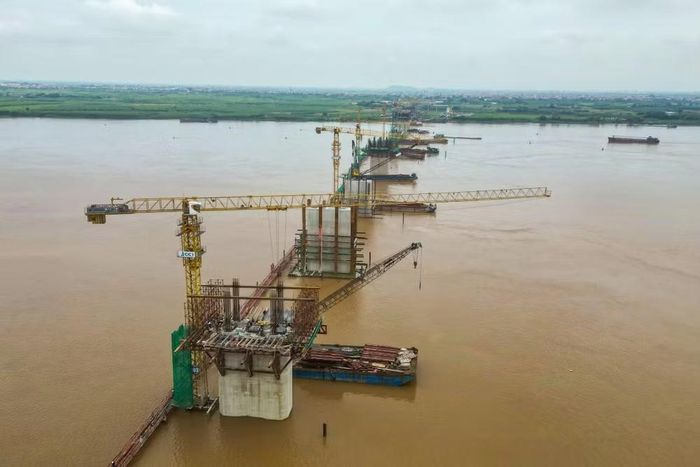 Dải 9 trụ chính khu vực lòng sông đã hiện rõ hình hài. Việc đưa móng bệ và thân trụ ngoi lên khỏi mặt nước đúng tiến độ giúp công trình an toàn đi qua mùa mưa lũ tiểu mãn năm 2026.