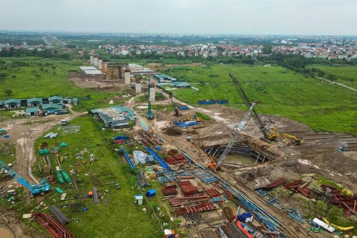 Công trường trung tâm đặt tại bờ thuộc xã Ô Diên gồm trạm trộn, khu bãi thép và nhà điều hành. Xe bồn, máy xúc di chuyển liên tục để cung ứng vật tư cho 34 mũi thi công trên toàn tuyến.