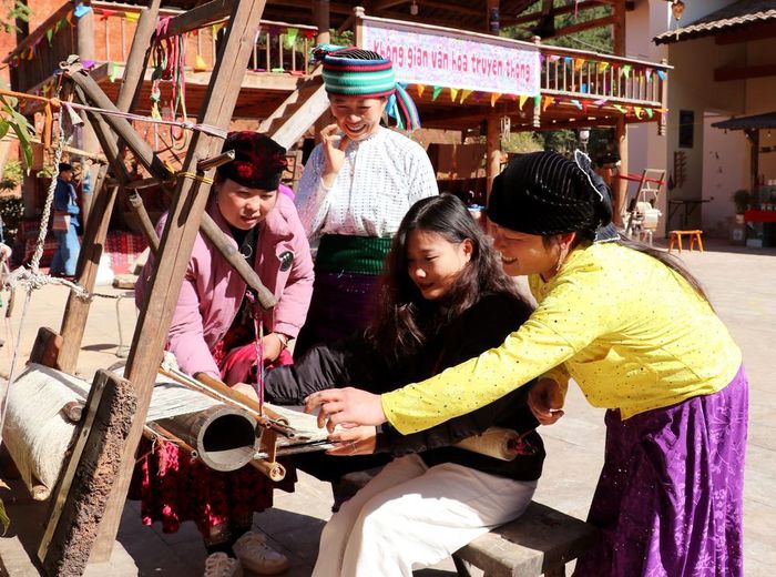 Du khách được trải nghiệm thực tế và được nghệ nhân hướng dẫn dệt thổ cẩm tại Không gian văn hóa truyền thống xã Đồng Văn (Tuyên Quang). Ảnh: Đức Thọ - TTXVN