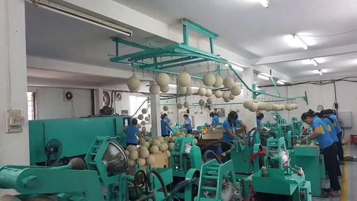 Người lao động với dây chuyền sản xuất bóng thi đấu tại Công ty cổ phần Động Lực. (Ảnh: HOÀI THU)