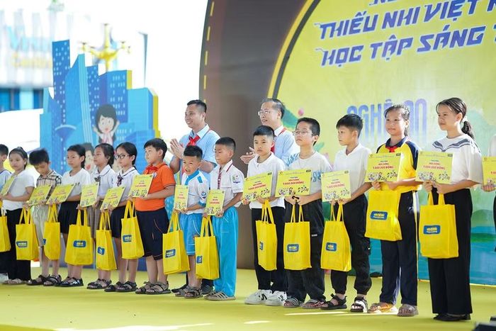 Đại diện Ban tổ chức trao học bổng tặng thiếu nhi vượt khó học tốt. (Ảnh: Hội đồng Đội Trung ương cung cấp)