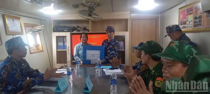 Đại diện chỉ huy Lữ đoàn 161, Vùng 3 Hải quân tặng quà động viên nữ du khách.