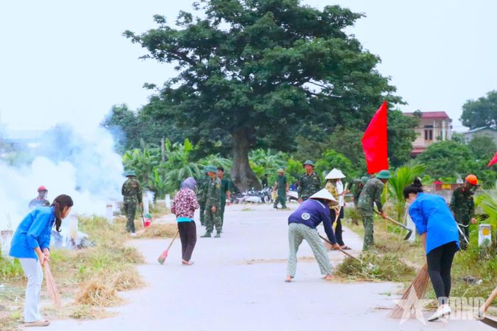 Cán bộ, chiến sĩ cùng nhân dân dọn dẹp, phát quang đường liên thôn trên địa bàn xã Hoạt Giang. 