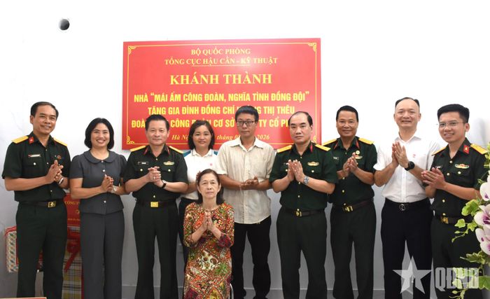 Các đại biểu dự khánh thành nhà "Mái ấm công đoàn, nghĩa tình đồng đội" chúc mừng gia đình đồng chí Hoàng Thị Thêu.