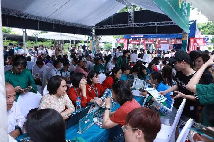 Thí sinh và người nhà đến tìm hiểu thông tin tuyển sinh của Học viện Tài chính sáng 4/7/2026. Ảnh: Đình Tuệ.