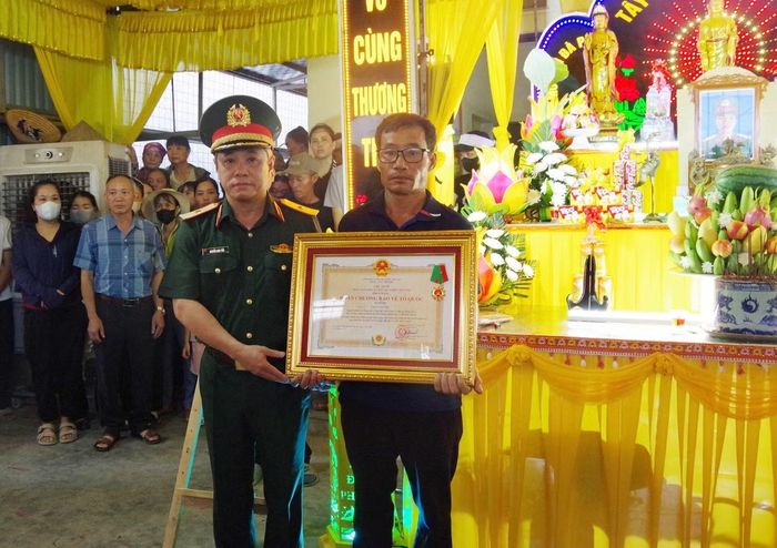 Thừa ủy quyền của Chủ tịch nước, Thiếu tướng Nguyễn Nam Tiến trao Huân chương Bảo vệ Tổ quốc hạng Ba cho đại diện thân nhân của Trung sĩ Cao Tuấn Anh.