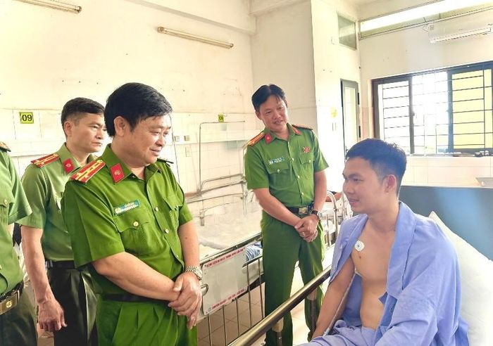 Đại tá Lê Đức Bảy, Phó Giám đốc Công an TP Cần Thơ thăm, động viên Thượng úy Trần Ngọc Lợi. Ảnh: Công an TP Cần Thơ