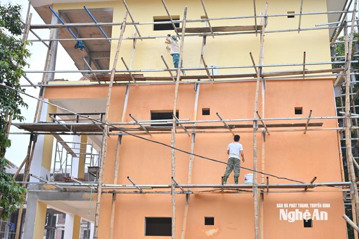 Hiện nay, các hạng mục của dãy phòng học và nhà hiệu bộ đang dần được hoàn thiện. Trong ảnh: Công nhân tiến hành quét sơn mặt ngoài của tòa nhà. Ảnh: Thành Cường