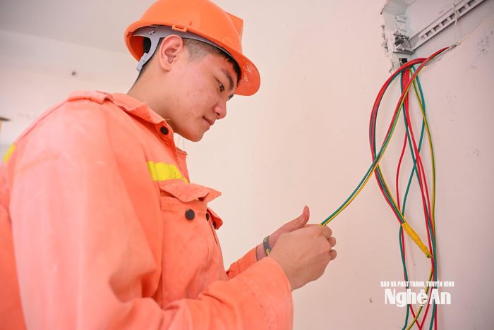 Công nhân thi công hệ thống điện các phòng học. Ảnh: Thành Cường