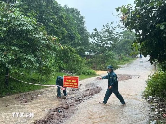 Chính quyền xã Lao Bảo (Quảng Trị) cắt cử lực lượng ứng trực, cắm biển cảnh bảo tại khu vực ngập sâu. (Ảnh: TTXVN phát)