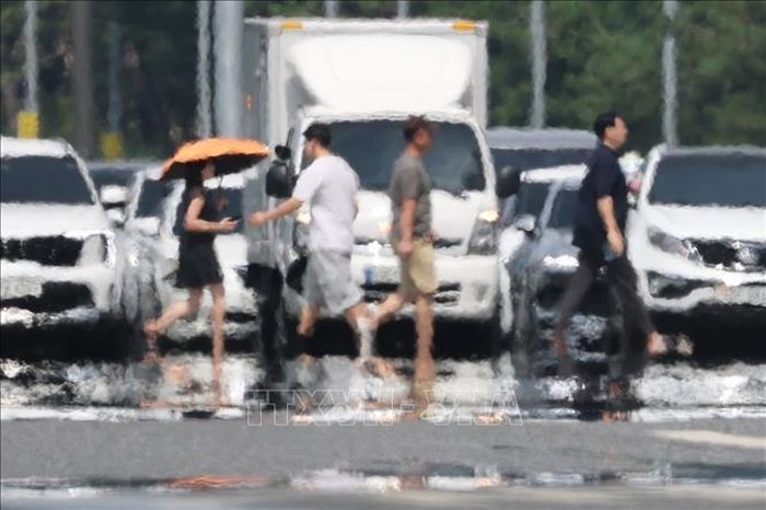 Người dân di chuyển trên đường dưới trời nắng gay gắt tại Seoul, Hàn Quốc ngày 4/8/2026. Ảnh: Yonhap/TTXVN phát