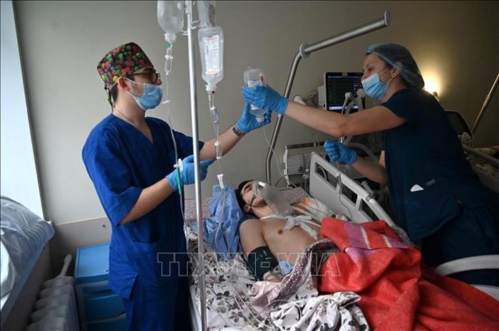 Nhân viên y tế chăm sóc một quân nhân Ukraine bị thương do chiến sự tại bệnh viện ở Kiev. Ảnh: AFP/TTXVN