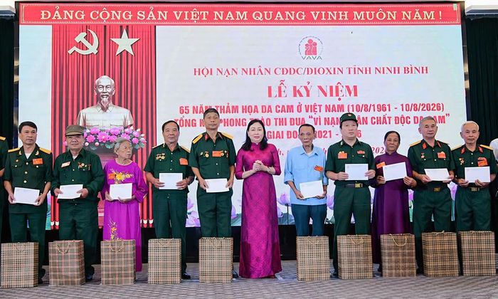 Bà Đinh Thị Lụa, Phó Bí thư Tỉnh ủy, Chủ tịch Ủy ban MTTQ Việt Nam tỉnh Ninh Bình, trao quà của tỉnh cho nạn nhân chất độc da cam/dioxin có hoàn cảnh khó khăn