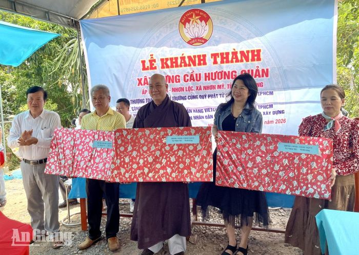 Bí thư Đảng ủy, Chủ tịch HĐND xã Nhơn Mỹ Trần Ngọc Bầu tặng quà cảm ơn nhà tài trợ.