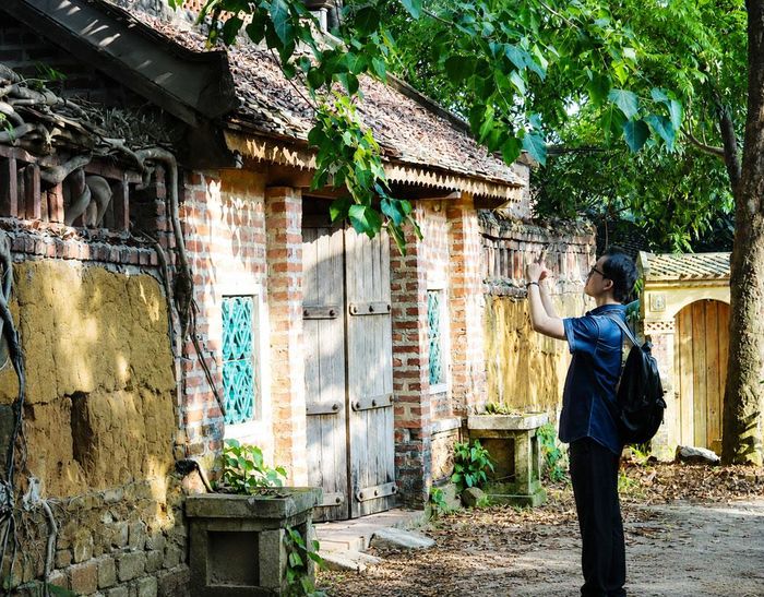 Du khách tham quan những ngôi nhà cổ ở thôn Kiều Na (xã Liên Bão).