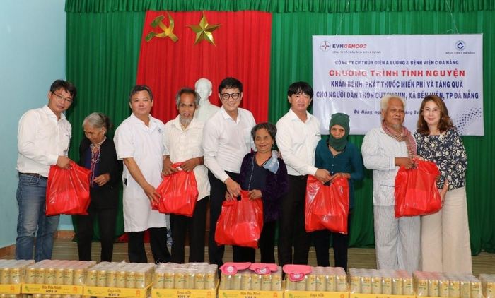 Đại diện Công ty Cổ phần Thủy điện A Vương và Bệnh viện C Đà Nẵng trao quà cho người dân. Ảnh: VĂN LÃM
