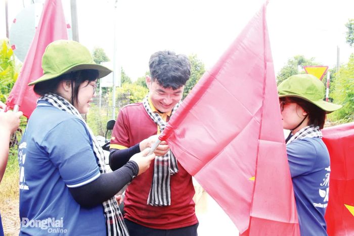 Cán bộ Đoàn, sinh viên Trường đại học Công nghệ Miền Đông tham gia chiến dịch tình nguyện Mùa hè xanh thực hiện tuyến đường cờ tại xã Phú Vinh.