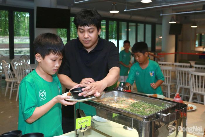 Các em thưởng thức bữa ăn tại doanh nghiệp trong chuyến tham quan. Ảnh: Thủy Tiên