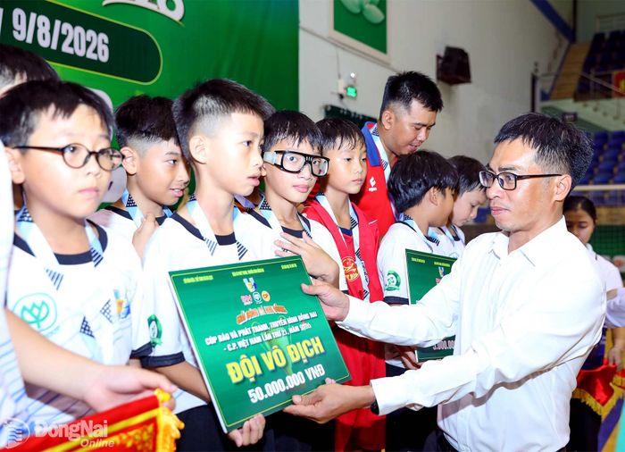 Đại diện Công ty cổ phần chăn nuôi C.P. Việt Nam trao bảng tiền thưởng cho đội U.11 Long Thành. Ảnh: Huy Anh