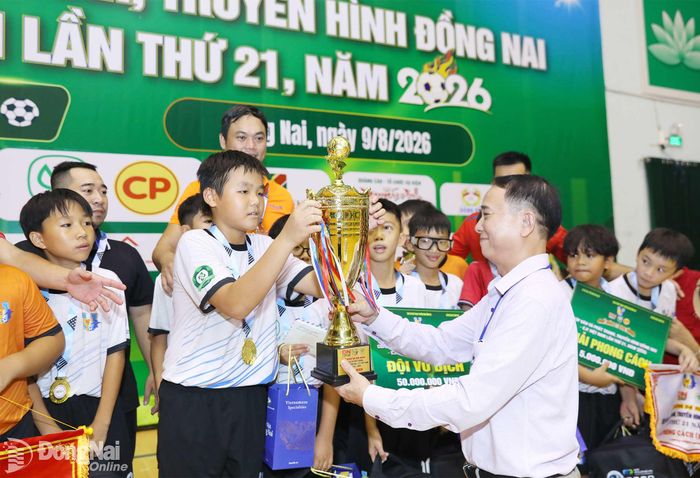 Phó Giám đốc phụ trách Báo và Phát thanh, Truyền hình Đồng Nai, Trưởng ban Tổ chức giải Cao Quốc Sang trao cúp vô địch cho đội U.11 Long Thành. Ảnh: Huy Anh