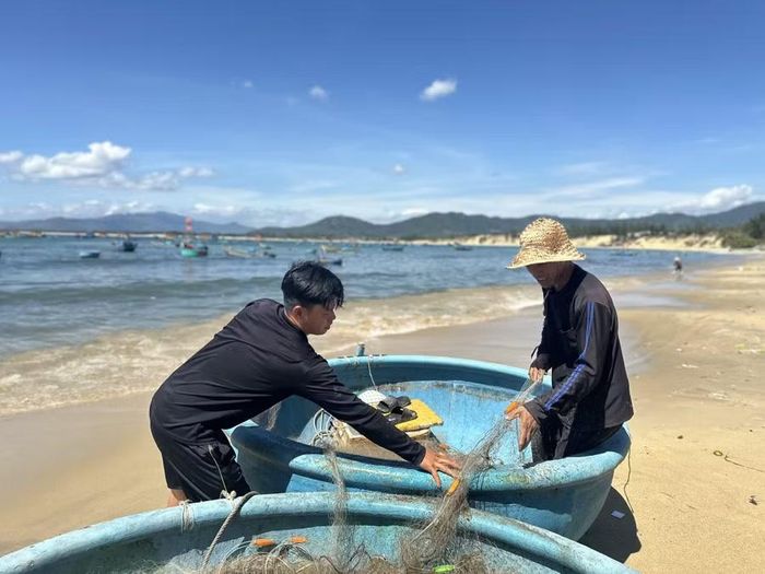  Hai ngư dân đang thau lưới sau một đêm hành nghề. Ảnh: Ngọc Quỳnh 