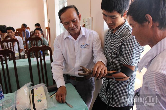 Cán bộ thực địa của AEPD hướng dẫn lắp tay giả cho người khuyết tật - Ảnh: AEPD