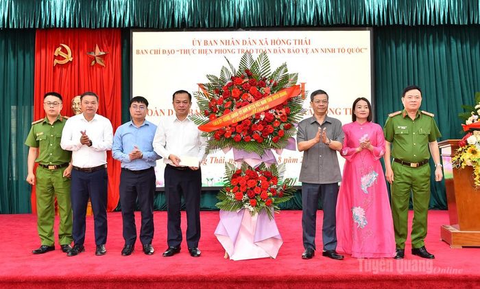 Đồng chí Nguyễn Văn Sơn, Chủ tịch HĐND tỉnh tặng hoa chúc mừng Ngày hội Toàn dân bảo vệ an ninh Tổ quốc xã Hồng Thái.