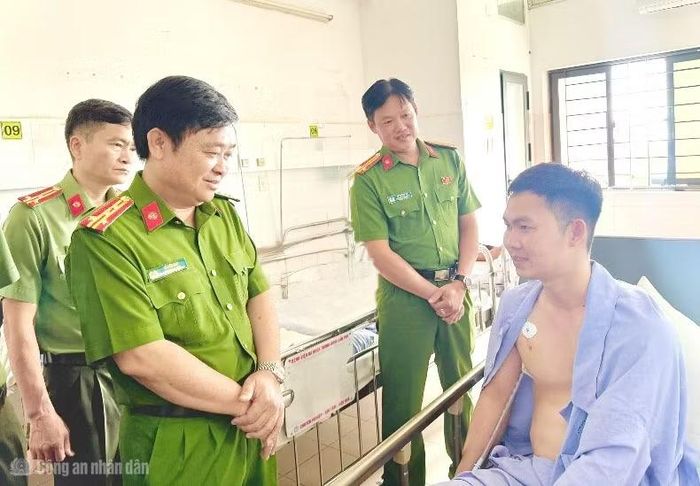 Đại tá Lê Đức Bảy, Phó Giám đốc Công an TP Cần Thơ thăm hỏi, động viên Thượng úy Trần Ngọc Lợi.
