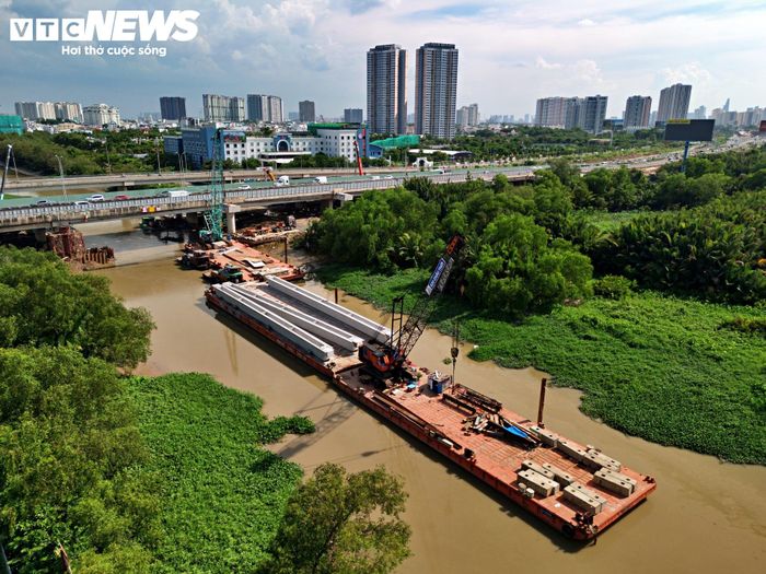 Tại khu vực cầu Kênh Mương, hàng chục công nhân cùng máy móc, thiết bị được huy động để tăng tốc thi công. Các phiến dầm được vận chuyển, tập kết ngay cạnh cầu, chuẩn bị cho công tác lao lắp.