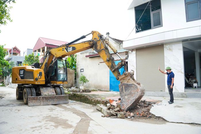 Các hộ dân và lực lượng tham gia giải phóng mặt bằng thực hiện dự án. Ảnh: Diệu Hương